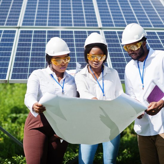 African american technician checks the maintenance of the solar panels. Group of three black engineers meeting at solar station.